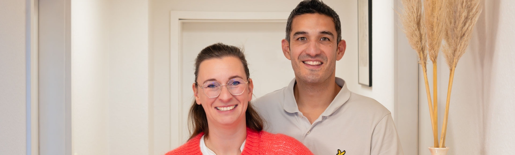 Eva und René Krüger stehen im hellen Eingangsbereich ihrer Osteopathie und Lasertherapie Praxis, dem Complementarium, in Stralsund.